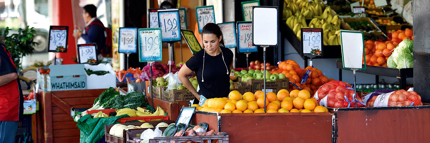 Woman picking fruit on Belmore Road shops in Riverwood, South Sydney NSW. Credit: NSW Department of Planning and Environment / Adam Hollingworth