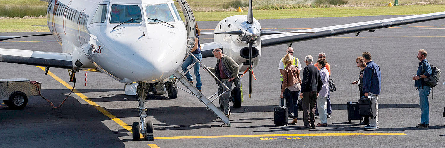 People boarding a plane at Merimbula Airport. Merimbula, NSW. Credit: NSW Department of Planning and Environment / Jaime Plaza Van Roon