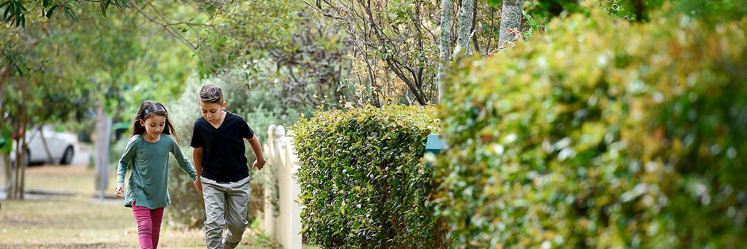 Siblings holding hands on a residential street in Frenchs Forest, North Sydney NSW. Credit: NSW Department of Planning and Environment / Adam Hollingworth