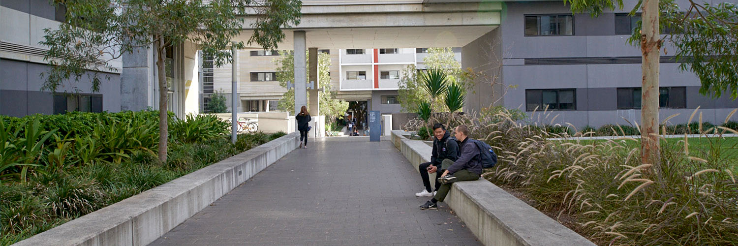 Two people sitting in a large housing development.