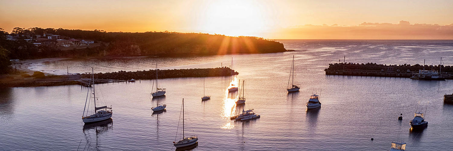 Small boats in the bay at sunset.