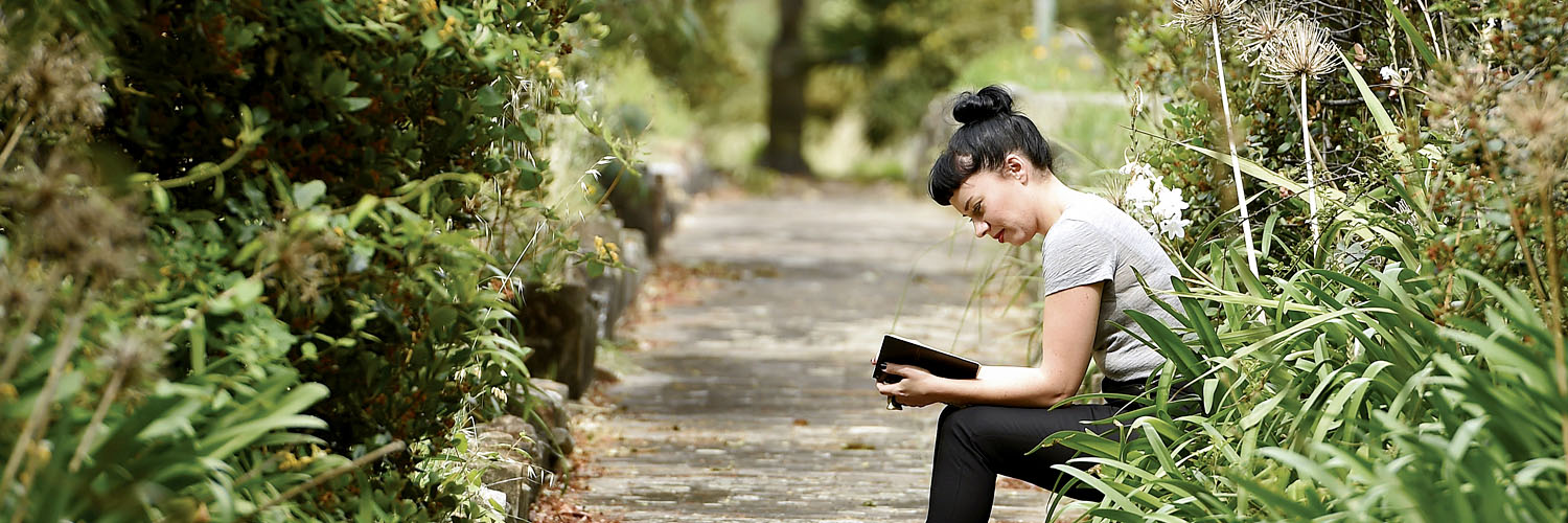 Woman reading on a bench in St Leonards, North Sydney, NSW. Credit: NSW Department of Planning and Environment / Adam Hollingworth