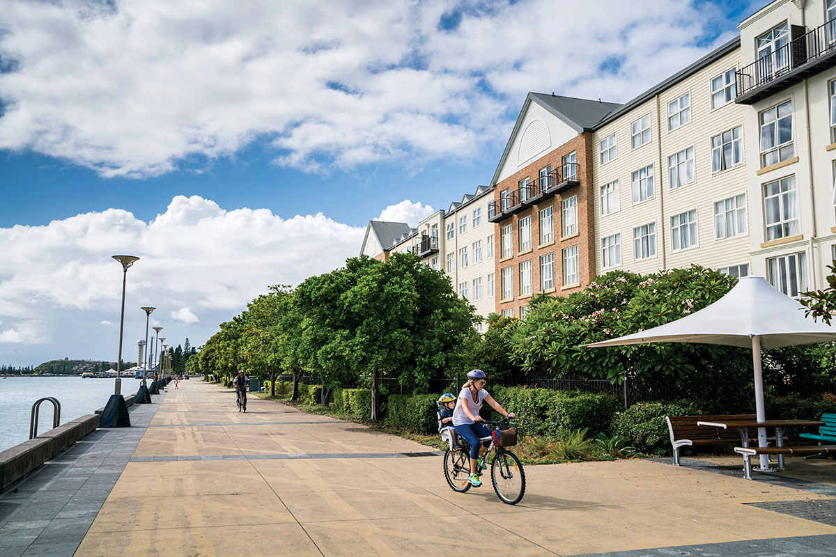 People walk or ride their bicycles along the boardwalk at Honeysuckle Precinct. Newcastle, NSW. Credit: NSW Department of Planning and Environment / Jaime Plaza Van Roon