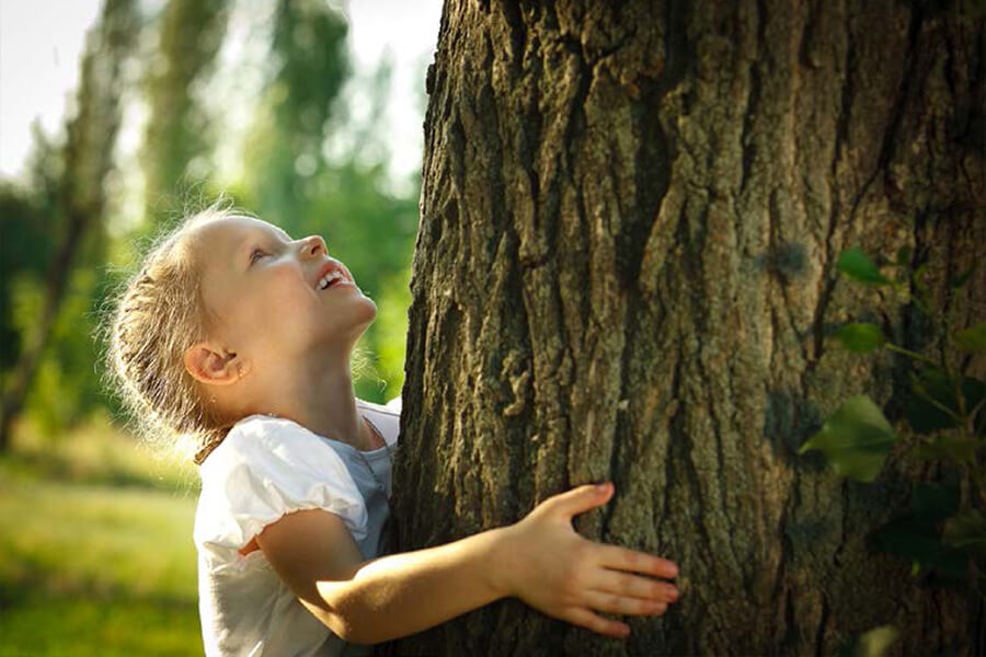 Child hugging a tree. No image credit.