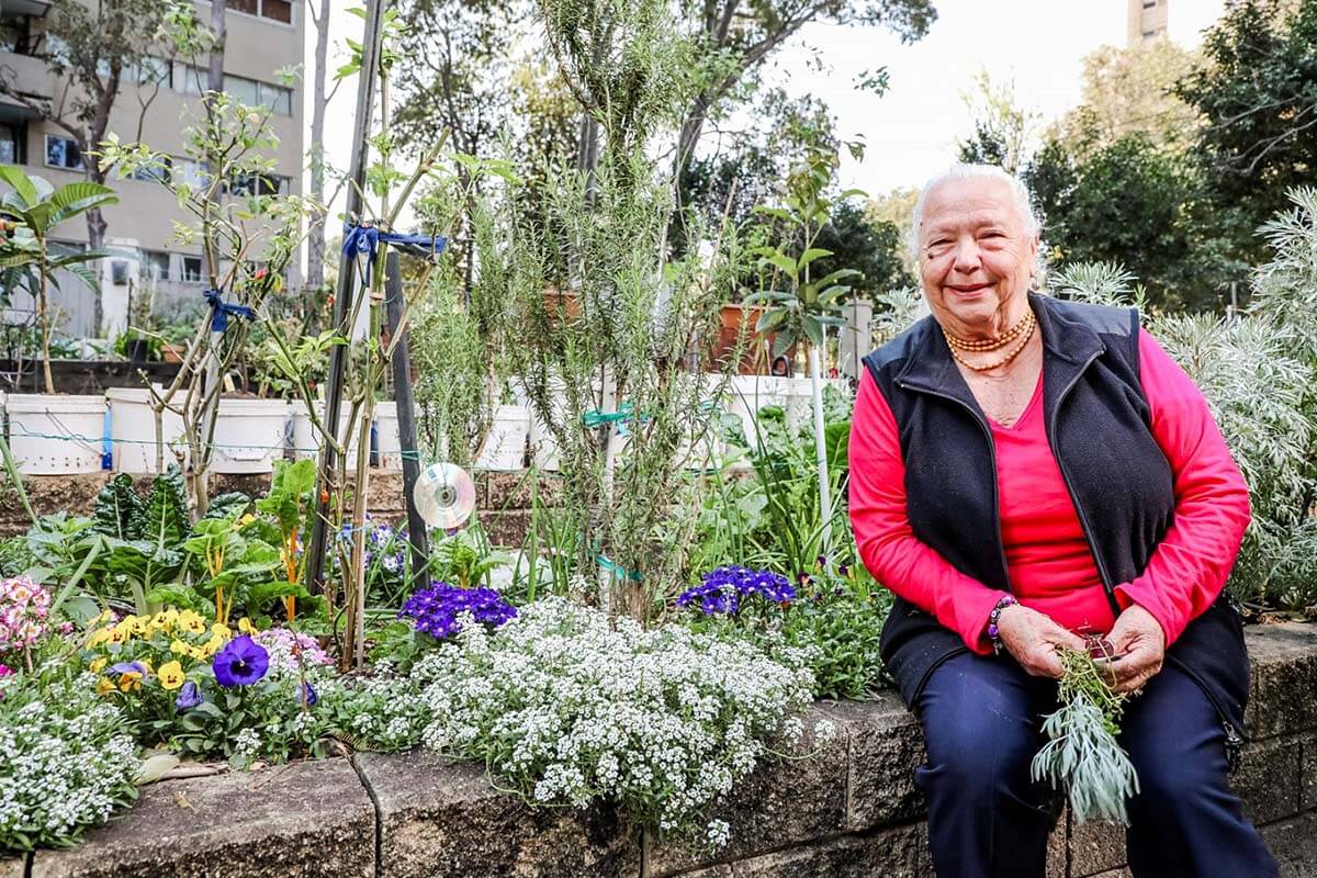 NSW Land and Housing Corporation social housing tenant sitting in front of the community garden.