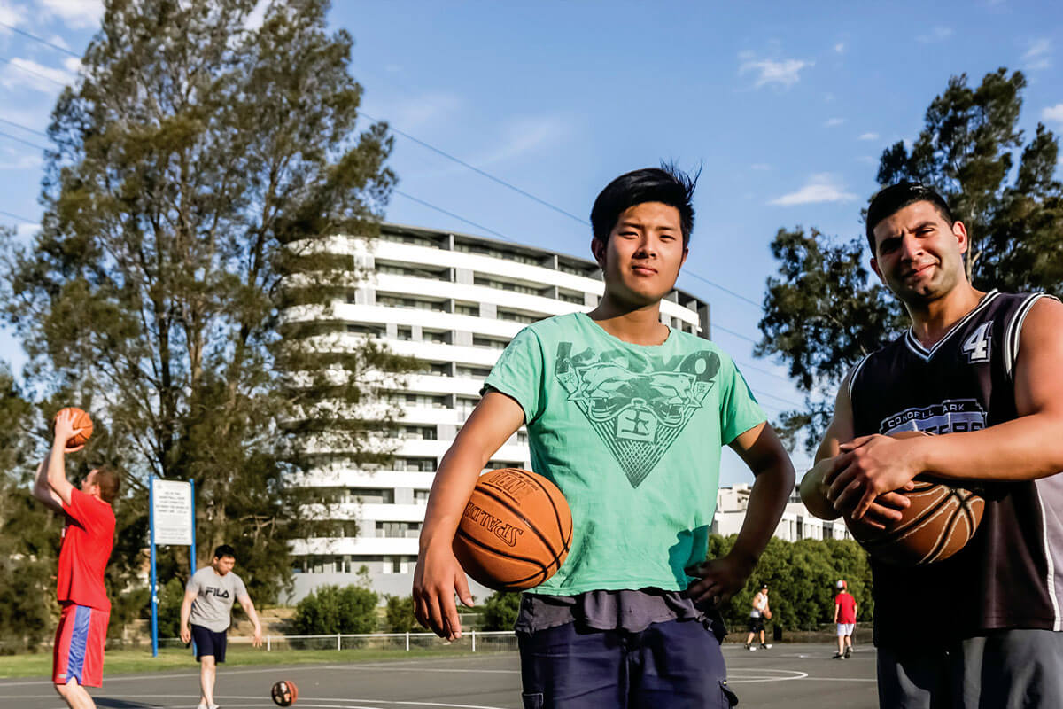 Two young men with basketballs in Tasker Park. Canterbury, Sydney, NSW. Credit: NSW Department of Planning, Housing and Infrastructure / Salty Dingo