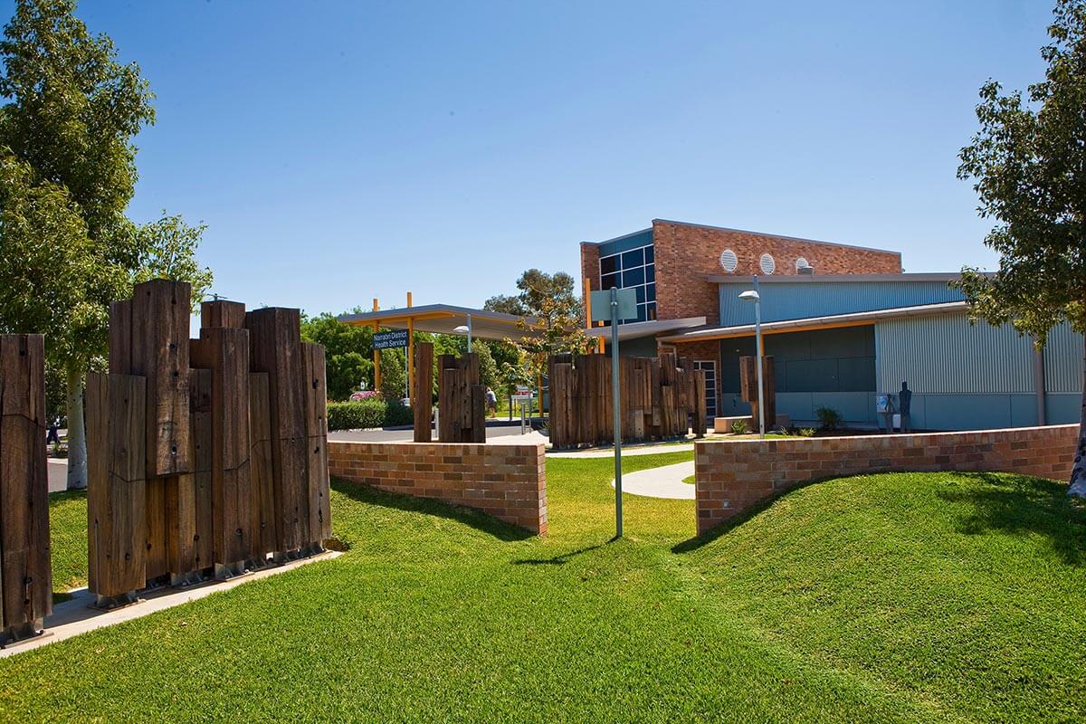 The Narrabri District Health Service building, surrounded by a fence, with a clear sign in front.