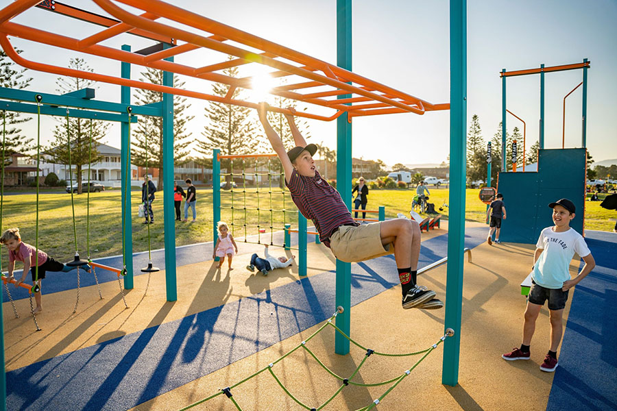 Children playing at a playground at Reddall Reserve, Lake Illawarra NSW. Credit: NSW Department of Planning, Housing and Infrastructure / Dee Kramer