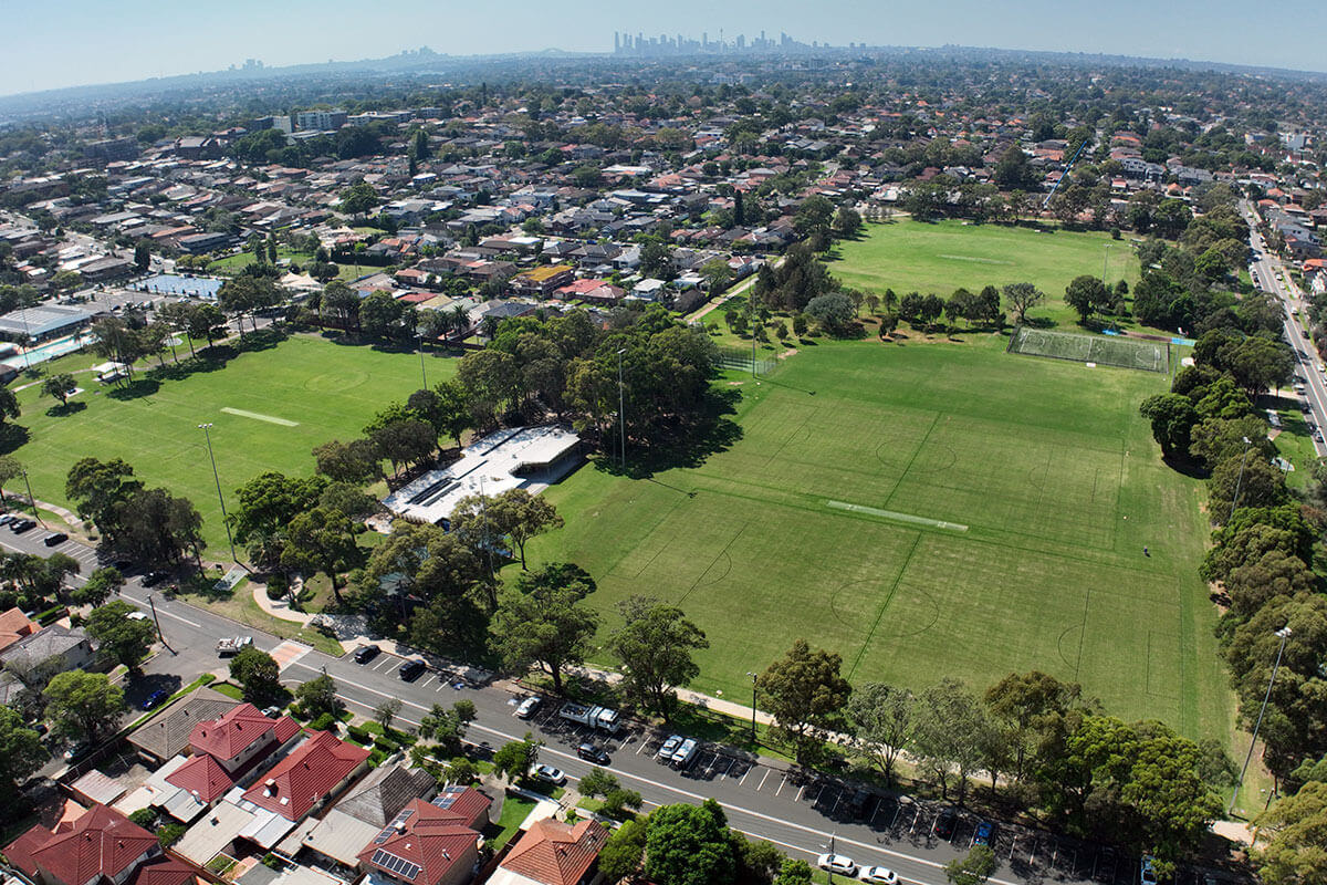 Aerial view over the grassy playing fields and surrounding housing at Henley Park, Enfield NSW. Credit: DPHI