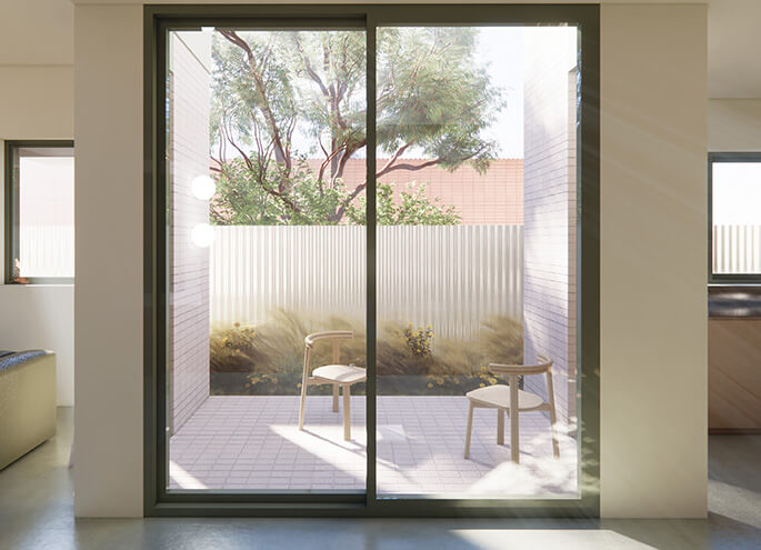 Semis 02 by Sibling Architecture view from dining room through the window and into the central courtyard with two chairs and bushes along the fence. Credit: Choi Render