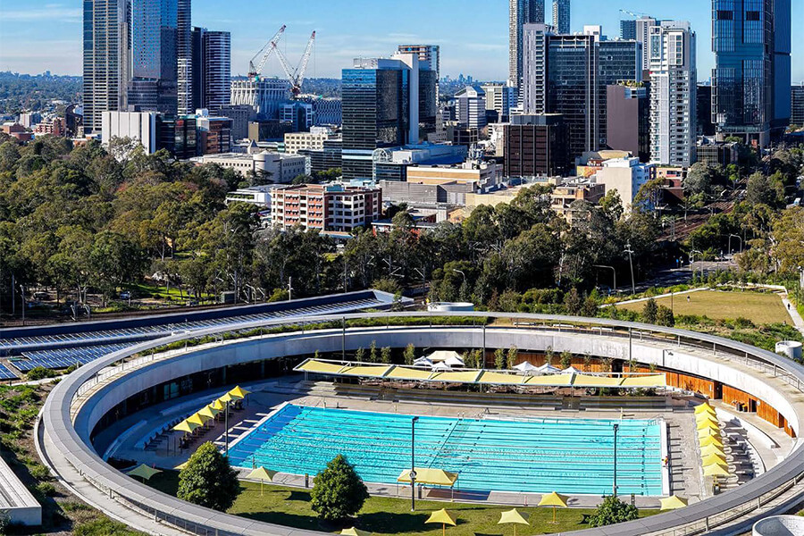 Aerial view of city with pool and buildings in sight.
