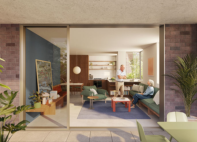 View into living room of apartment from the balcony with two people talking inside. 