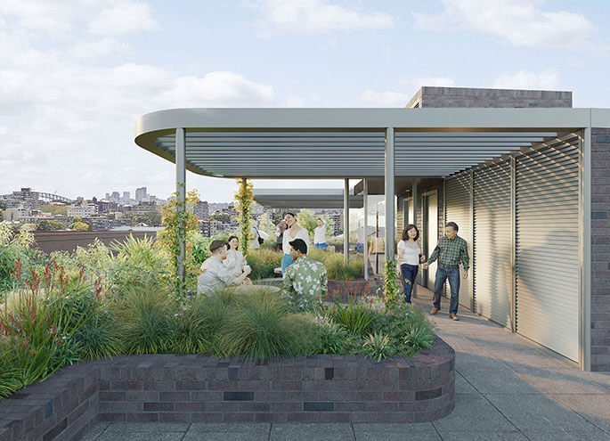 View of sheltered communal area with people interacting and plants in foreground.