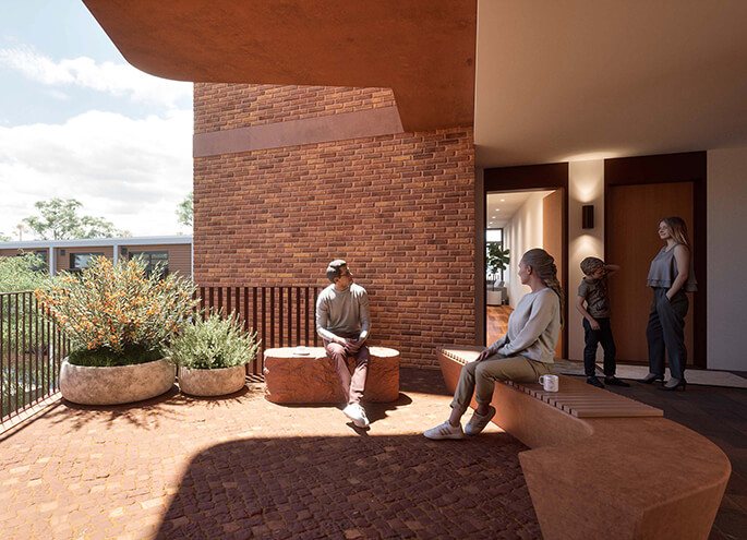 View of two people seated at a bench in the open foyer of this apartment building.